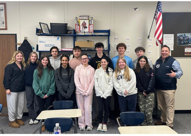 Justin Thurber posing with a high school class during a school visit