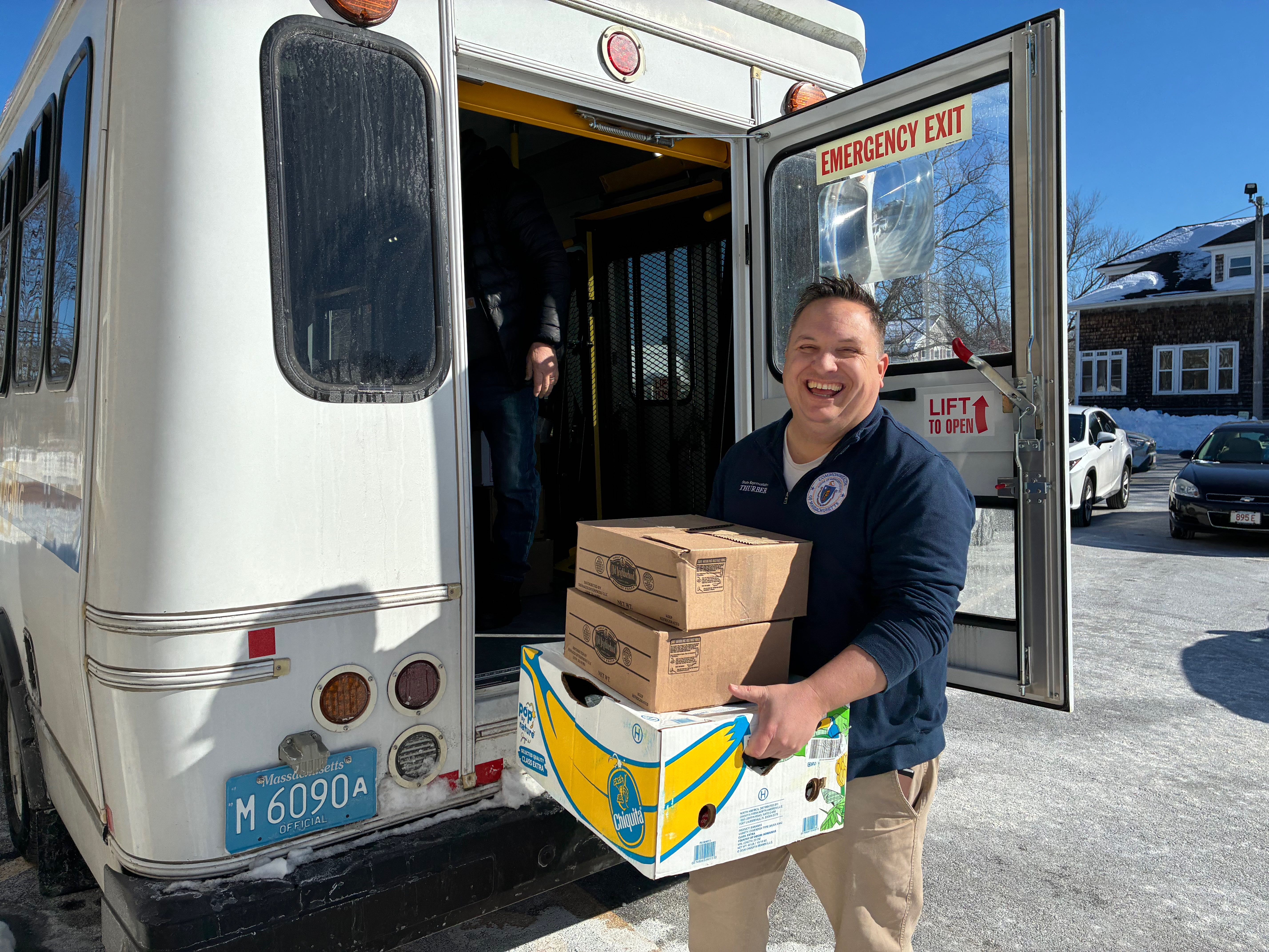 Justin Thurber carrying boxes of food during a winter food delivery