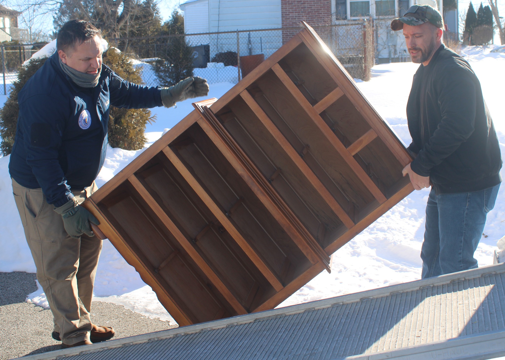 Justin Thurber helping a veteran move furniture in the snow